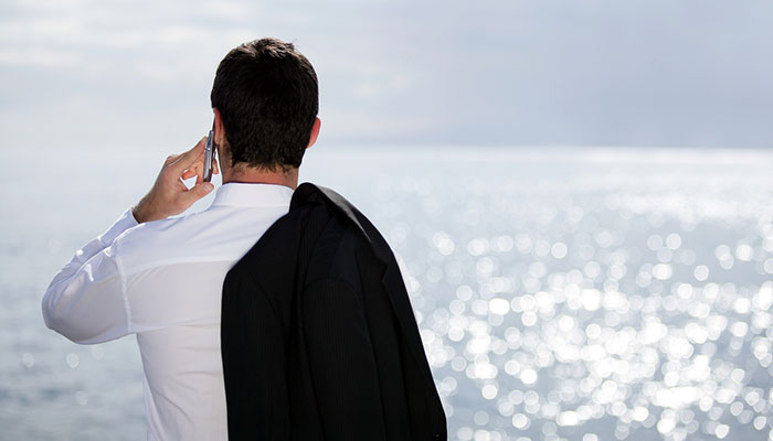 businessman takes a call on the coast