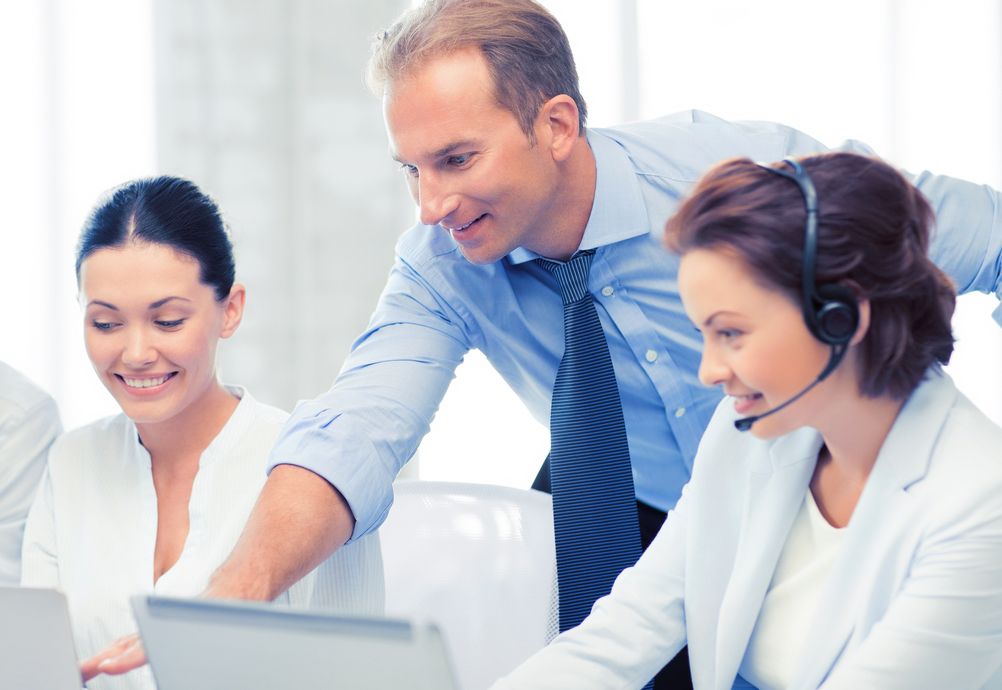 Three people in a Call Answering office.